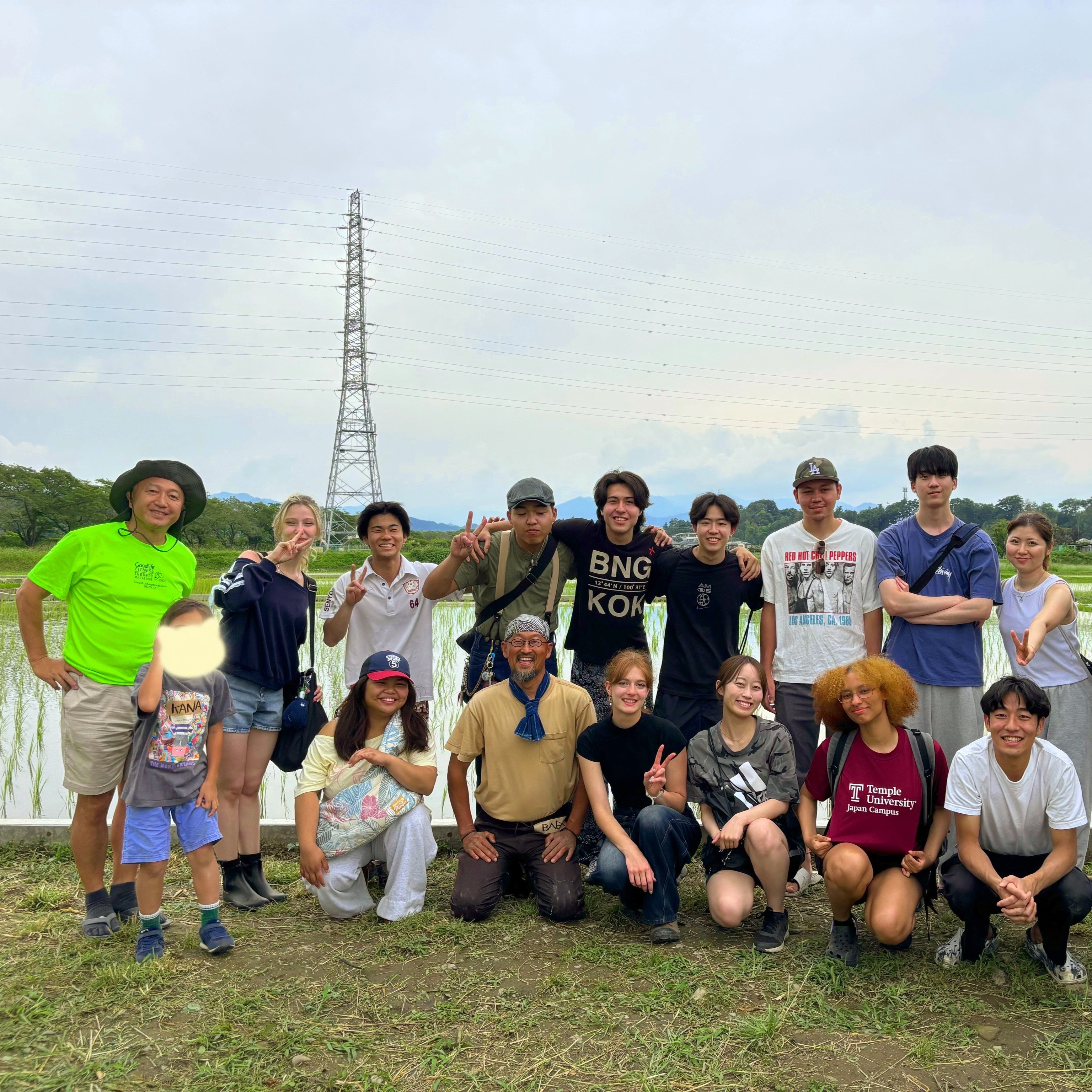 Hosei and TUJ students smiling by a rice paddy