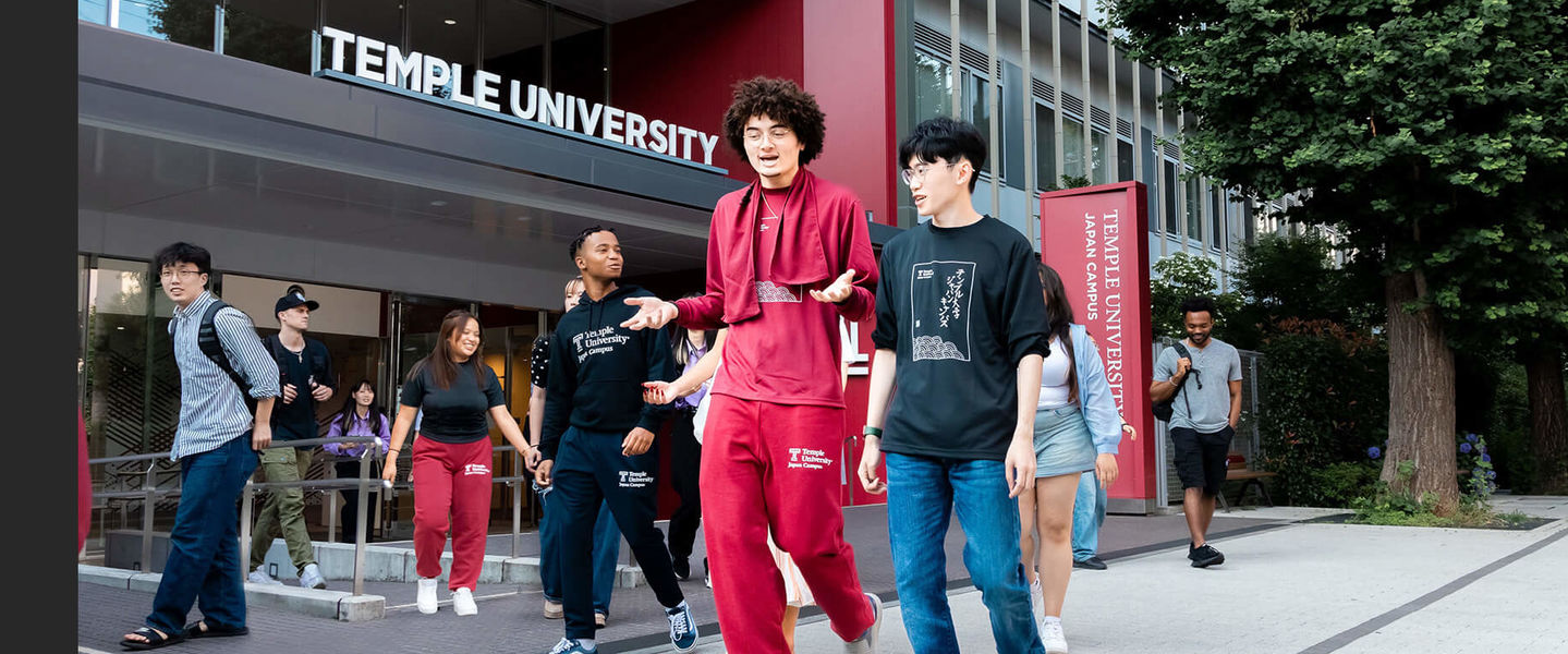 Students walk in front of the TUJ campus entrance.