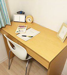An image of a standard single room equipped with a desk and chair.