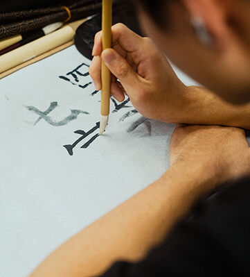 A TUJ student is writing kanji in