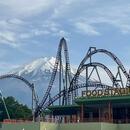 A picture of Fuji-Q highland rollercoasters with Mt. Fuji in the background. 