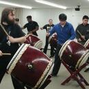 A picture of students hitting taiko drums.
