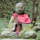 A moss-covered Jizo statue in nature