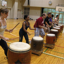Several men and women playing Japanese drums