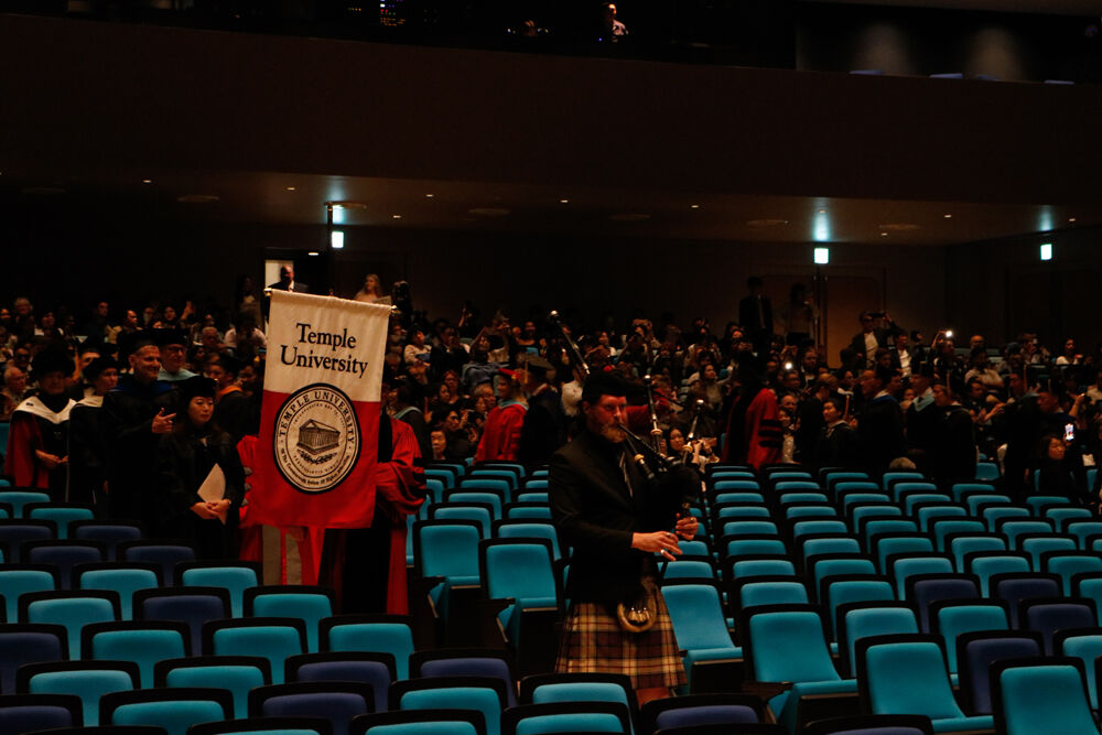 Bagpiper and faculty members