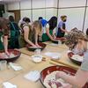 A picture of students making soba noodles.