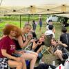 Students enjoying watermelon under a marquee after the rice planting
