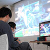 Two students are playing a video game.