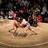 A picture of two sumo wrestlers fighting in the sumo ring.