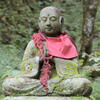 A moss-covered Jizo statue in nature