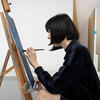 A female student painting on a canvas