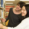 Two students are looking for books at the library.