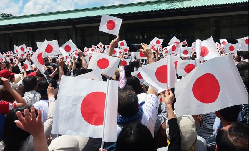 国旗を振り続ける人々
