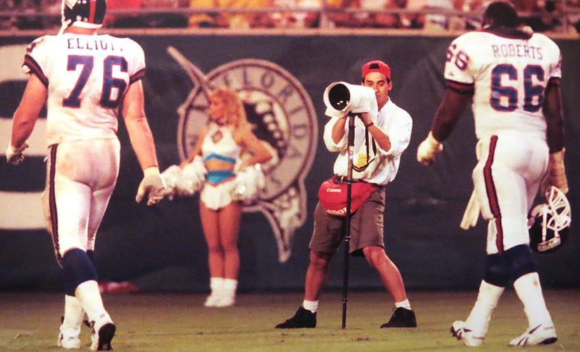 アメリカンフットボールの試合を撮影するジョージ