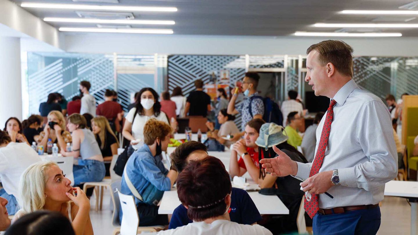 TUJ Dean Wilson talking with students in the cafeteria during Welcome Week.